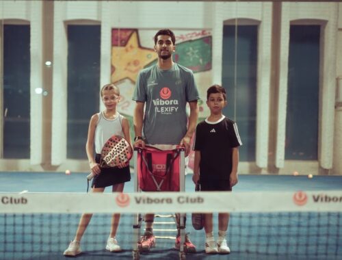 Fervente padelspelers in kleurrijke sportieve kleding op de baan, klaar om te spelen.