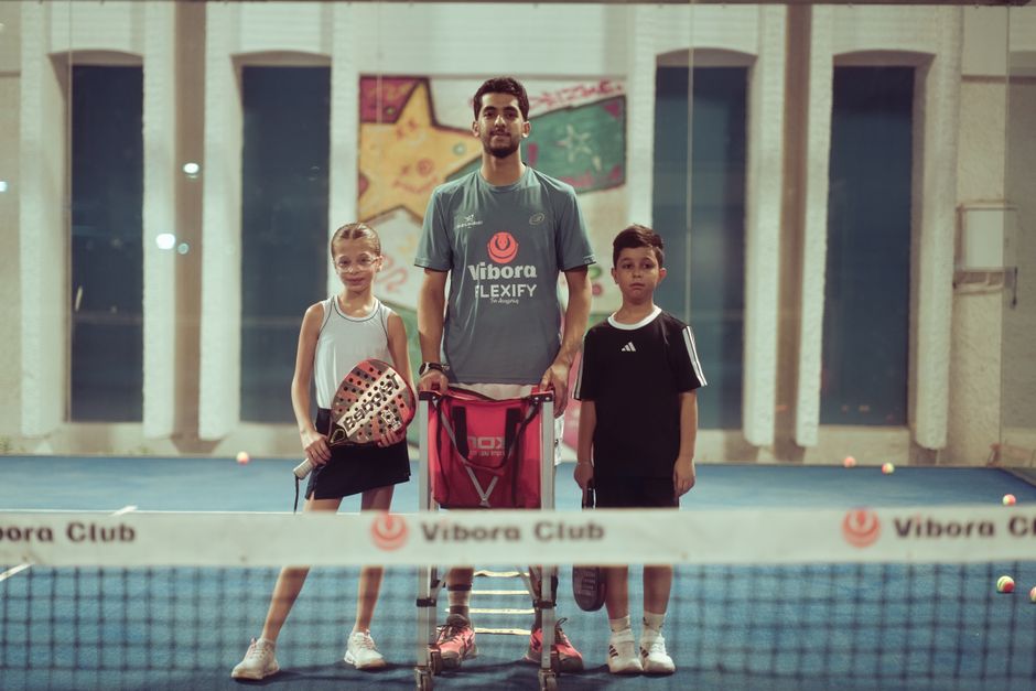 Fervente padelspelers in kleurrijke sportieve kleding op de baan, klaar om te spelen.